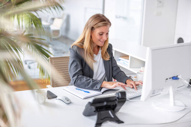 istock Confident and Focused Businesswoman Working on a Computer at her Desk 1341437548