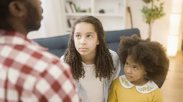 Strict African father scolding daughters for poor behavior, parenting moment