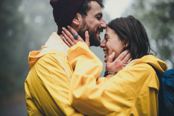 istock Happy affectionate couple in raincoats enjoying in nature. 1341439224