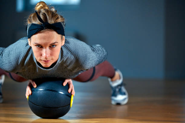 femme en forme et musclée avec des yeux perçants faisant un entraînement intensif avec kettlebell dans la salle de gym. - core workout photos et images de collection