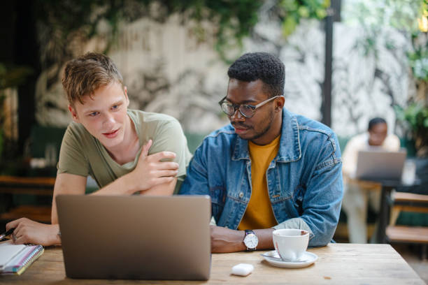istock Two male friends using laptop in a cafe 1341441117