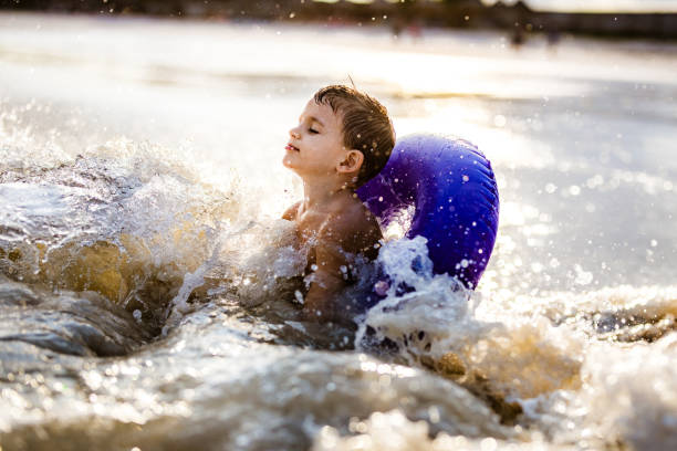 istock Little boy enjoying in the sea while swimming with inflatable ring. 1341441308