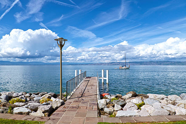 Swiss Alps above Lake Geneva, Switzerland. Jetty at Prangins on the West side of Lake Geneva looking across towards the Swiss alps on the Eastern side of the lake.