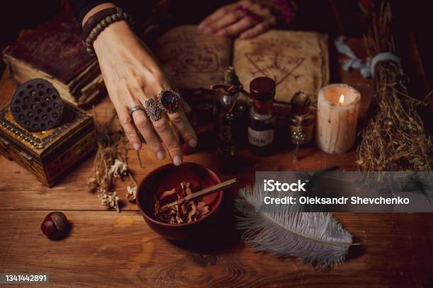 Female Witch Making Potion On Dark Background Magic Bottles With Potions And Candles On Table Of Alchemist Halloween Theme Stock Photo - Download Image Now