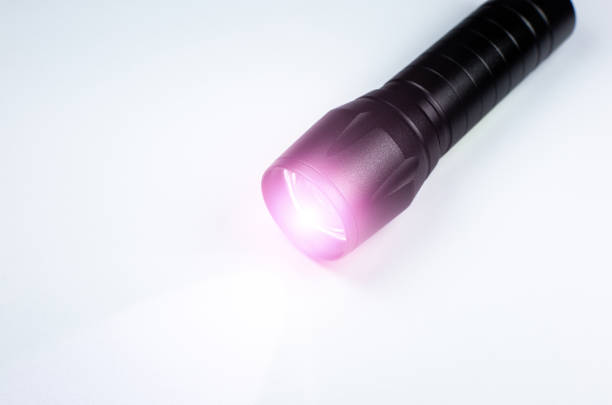 istock Black Flashlight and a ray of light on the white background. Close up photo. 1341443018