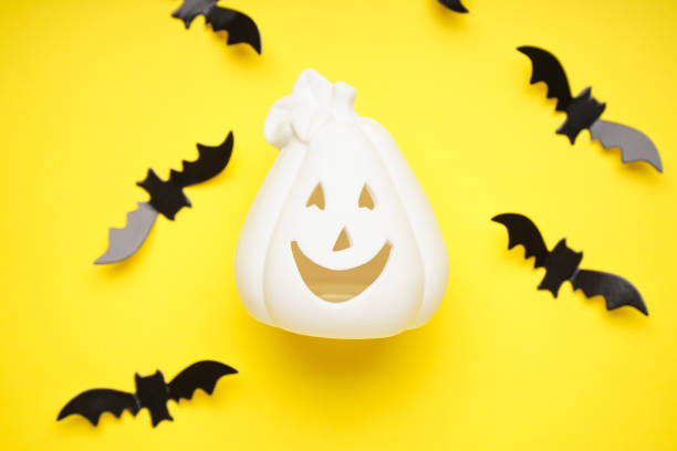 istock White halloween pumpkin and bats on a yellow background, flat lay. Halloween concept. 1341443132