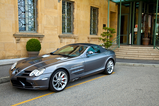 Neuchatel, Switzerland - August 10, 2011: Silver Mercedes McLaren SLR parked at the entrance of Hotel  Beau-Rivage in Neuchatel, Switzerland. This anglo-German sports car is developed by Mercedes-Benz and McLaren Automotive, built in Portsmouth and the McLaren Technology Centre in Woking, Surrey, England.