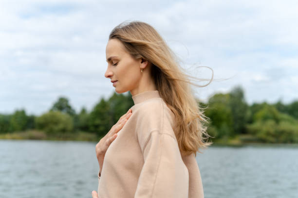 istock Woman's hand on her chest while doing breathing exercises and meditating. Harmony concept 1341445856