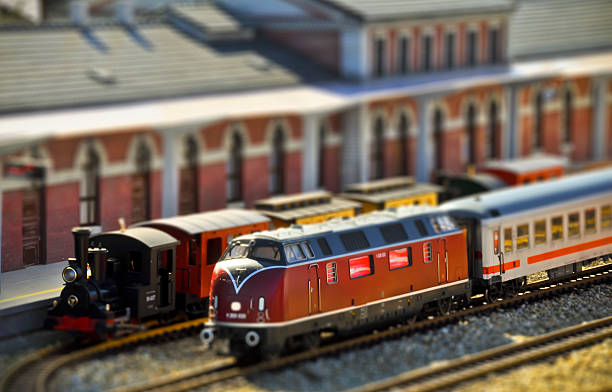 Steam and diesel trains on the railway station. Tilt shift Perfect models of the older (steam) and newer (diesel) locomotives and passenger trains wait on the railway station. Tilt-shift technique. tilt shift stock pictures, royalty-free photos & images