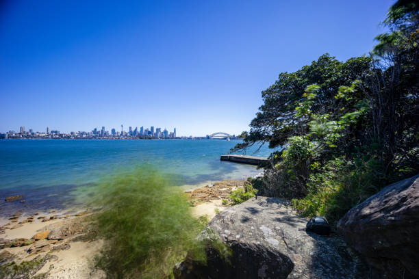 istock Sunny Spring day on Sydney Harbour with nice rocks in the foreground the soft waves crashing on the shore and the beautiful harbour foreshore as a backdrop NSW Australia 1341446089