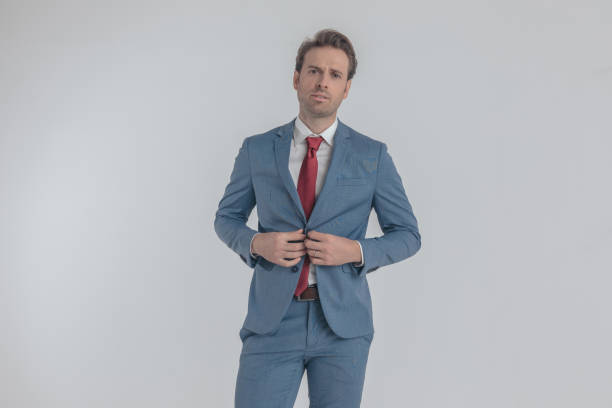 istock arrogant young businessman buttoning blue suit and being cool 1341446139