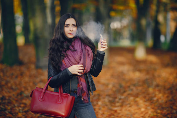 istock brunette girl is smoking an e-cigarette 1341446220