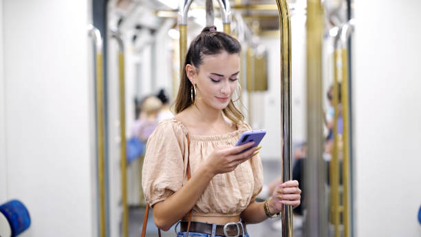 istock Woman using smart phone in subway train 1341446395