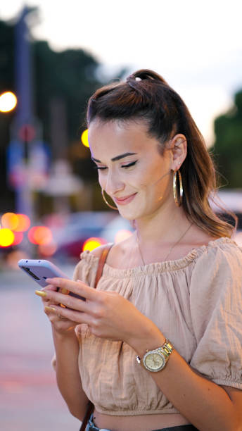 istock Woman using a smart phone in the street 1341446417