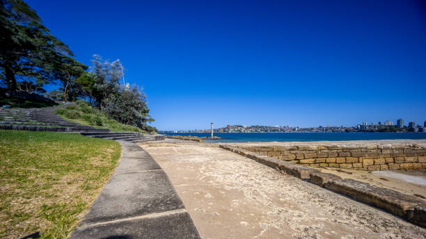 istock Sunny Spring day on Sydney Harbour with nice rocks in the foreground the soft waves crashing on the shore and the beautiful harbour foreshore as a backdrop NSW Australia 1341446527