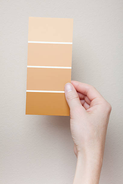istock Woman comparing paint swatches to beige wall 134144765