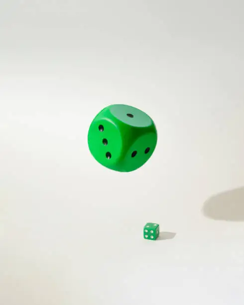 Photo of green dice flying above small one green dice.hazard casino concept idea