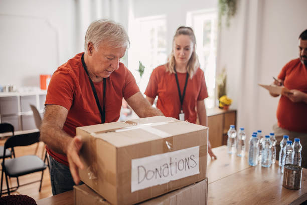 Senior man volunteer packing donation boxes
