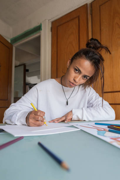 istock Portrait of a young Latina performs her college design homework while reviewing classes on her laptop from her bedroom at home 1341449052