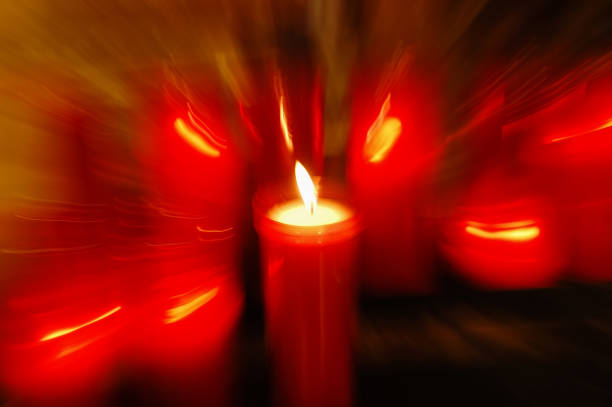 увеличить размытие красной свечи в храме во время молитвы - praye стоковые фото и изображения