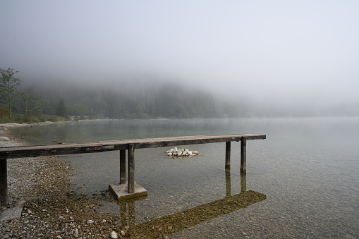 Early morning fog on Lake Bohinj, Slovenia with a small wooden jetty