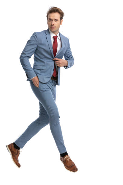 istock cool young guy holding hand in pocket and unbuttoning blue suit 1341457609