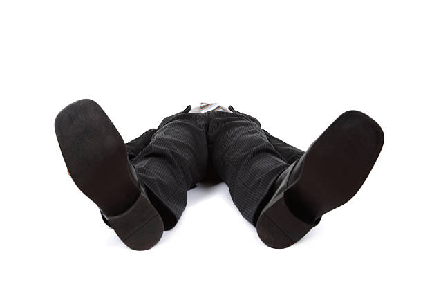 Knockout punch Businessman lying flat on the floor concept for defeat, exhaustion or just a bad day at the office flat shoe stock pictures, royalty-free photos & images