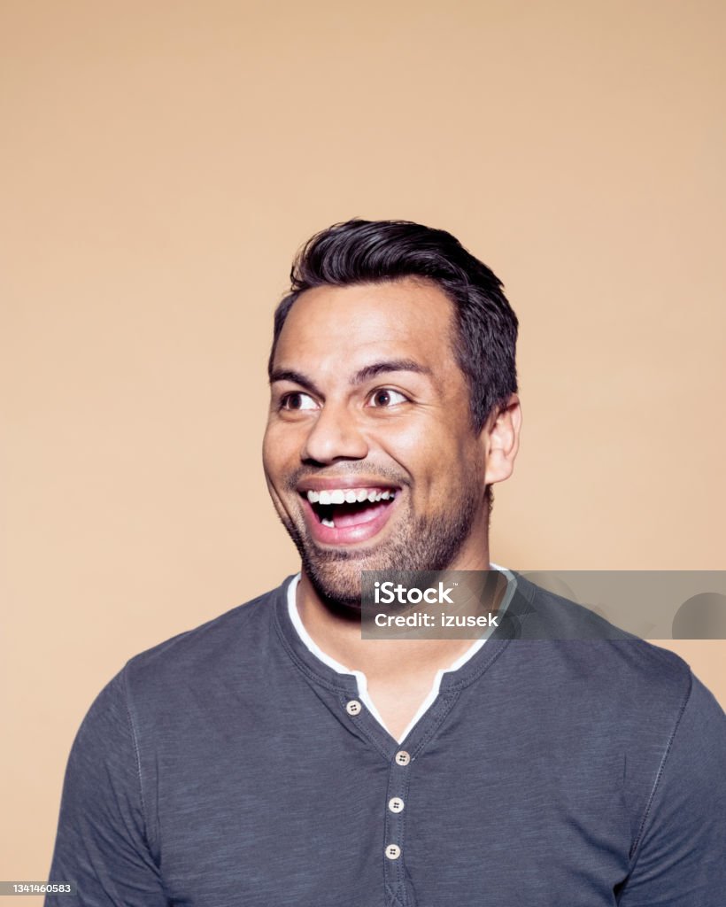 Excited man over brown colored background Headshot of suprised entrepreneur looking away. Confident mid adult man standing against brown background. 30-39 Years Stock Photo