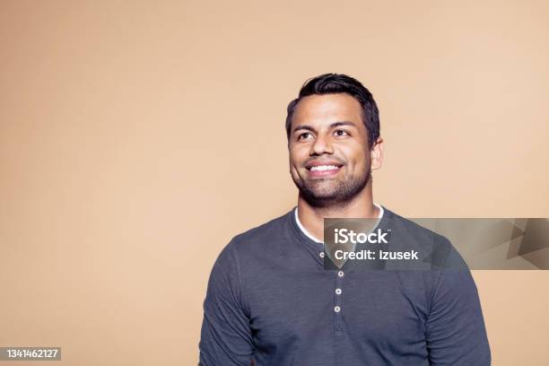 Smiling Man Over Brown Colored Background Stock Photo - Download Image Now - 30-39 Years, Latin American and Hispanic Ethnicity, Studio Shot