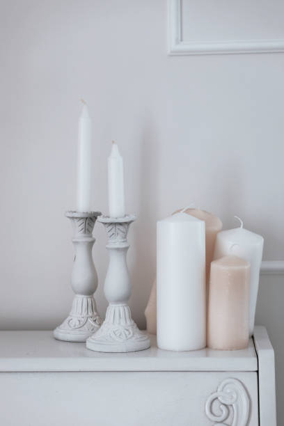 Beautiful composition with wax candles on piano. White room interior