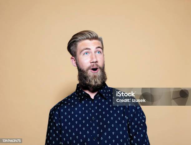 Surprised Young Man Standing Over Brown Background Stock Photo - Download Image Now - Beard, Men, Blond Hair