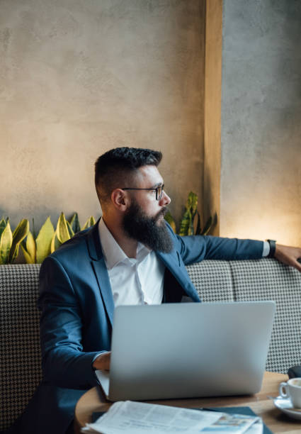 istock Serious Businessman Working on Laptop Computer in a Cafe 1341463745