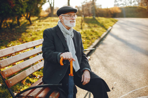 istock Elegant old man in a sunny autumn park 1341465122
