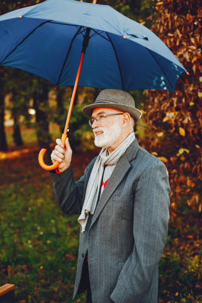 istock Elegant old man in a sunny autumn park 1341465140