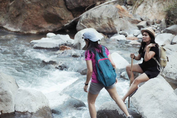 istock two young woman  hiking crossing a river 1341469418