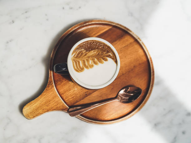 Coffee. Top view of latte art. Hot cappuccino on the white marble table. Vintage tone with slight noise film grained filter.