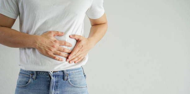 massaggio della mano dell'uomo adulto da vicino sullo stomaco dopo aver avuto dolore sensazione su sfondo bianco per concetto di salute e stile di vita - colon foto e immagini stock