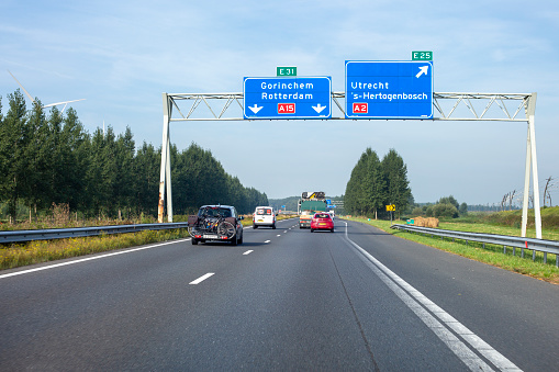 Deil, The Netherlands - September 06, 2021: Traffic on Dutch rijksweg A 15 nearby Knoppunt Deil. The A15 motorway (Dutch: Rijksweg 15) is a motorway in the Netherlands. It connects the Maasvlakte and Rotterdam in the West with the city of Enschede in the East. Some road users in the background.