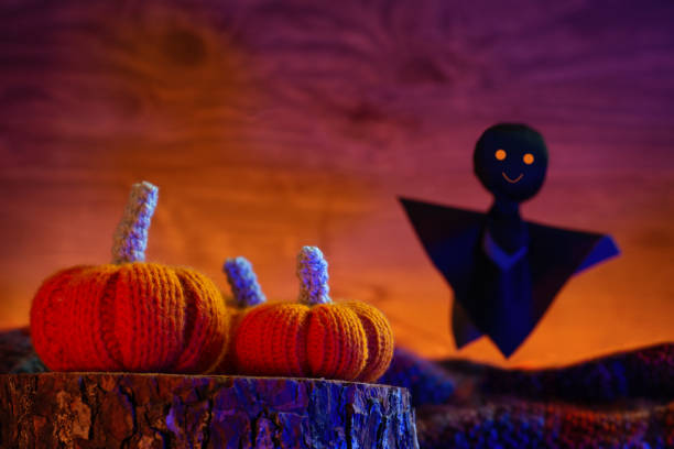 istock Halloween greeting card with pumpkins and a cute black ghost, orange backlight copy space 1341473425