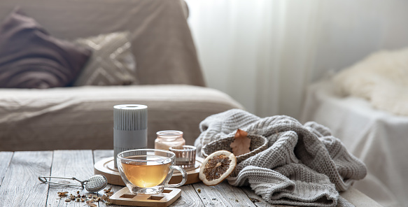 A cup of tea and details of autumn decor on a blurred background, copy space.