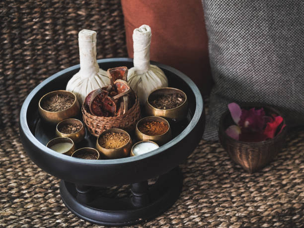 Therapy. Massage stamps and Thai herbs preparing for the massage treatment with soft focus on the bael fruit. Relaxing concept. Vintage film grained filter. stock photo