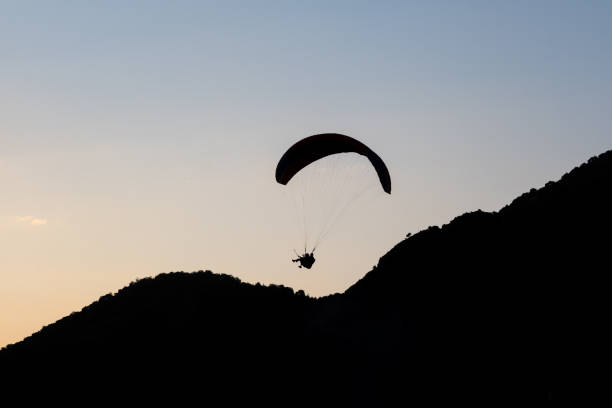 istock Silhouette shot of sunset mountains and paragliding 1341475920