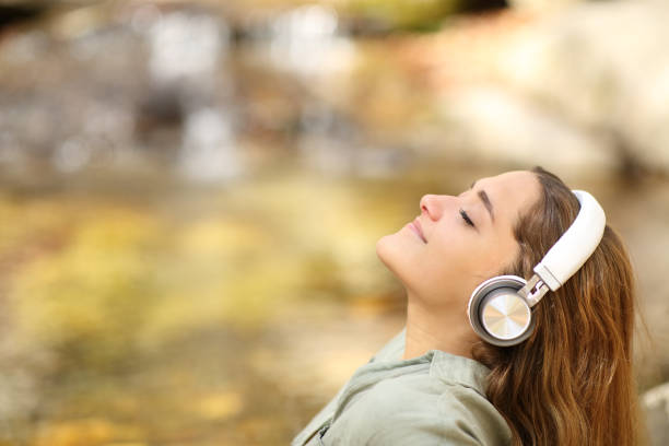 mujer respirando aire fresco escuchando música - grand river audio fotografías e imágenes de stock