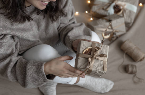 istock Beautiful Christmas present in female hands on a blurred background, top view. 1341476671