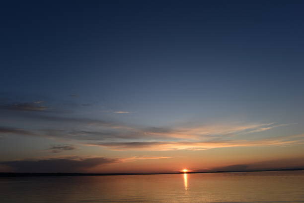 istock Sunbeam of the setting sun on the horizon on the water surface 1341476893