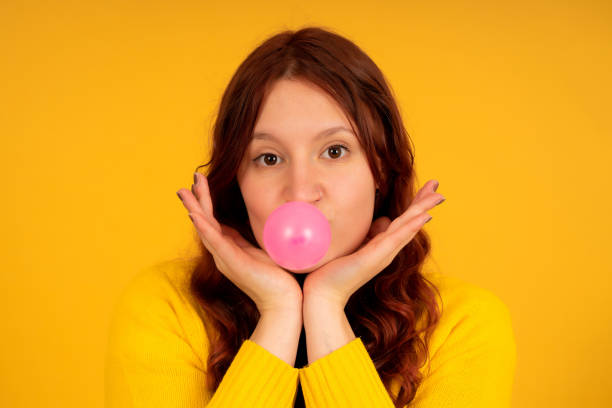 istock Young woman making a balloon with the chewing gum. 1341478923