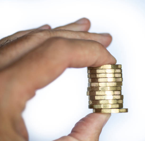 istock Man's hand holding a stack of one pound coin 1341479040