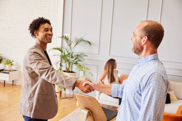 istock Two diverse businessmen smiling and shaking hands in an office 1341479220