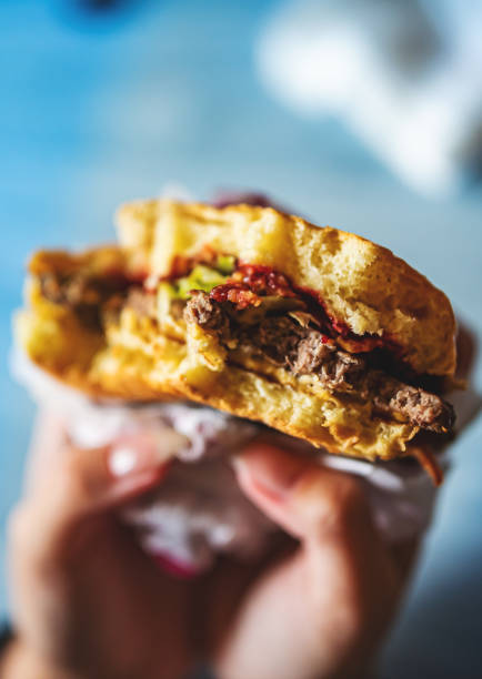 young woman holding in female hands fast food burger - cafe buns eating bildbanksfoton och bilder