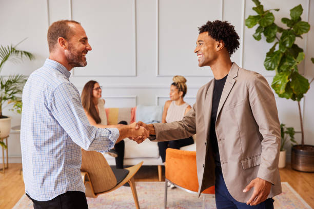 Two smiling diverse businessmen shaking hands in a modern office